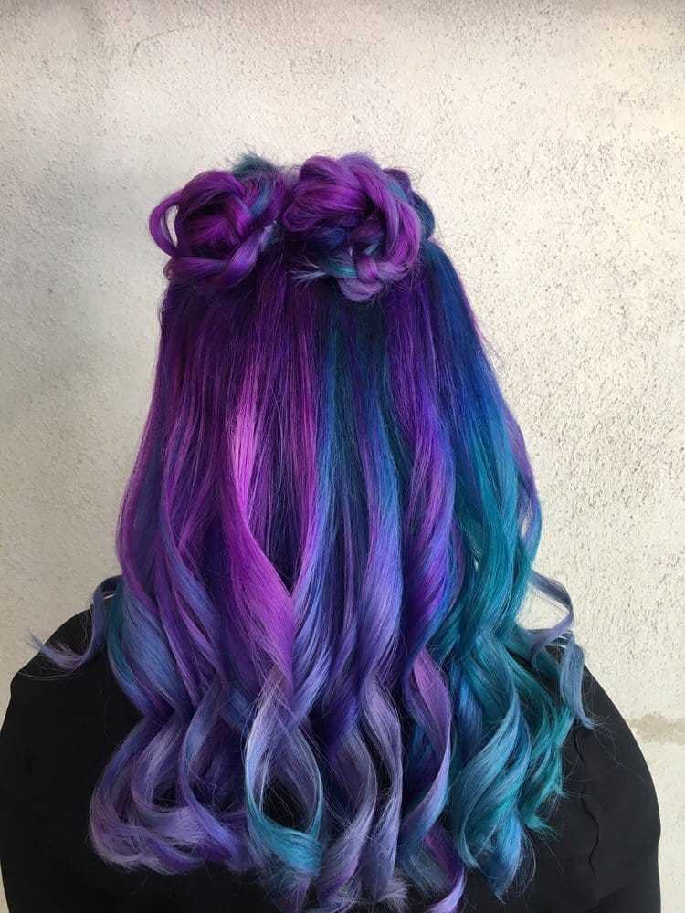 Vibrant hair with braided buns, blending purple, pink, and blue hues against a light background.